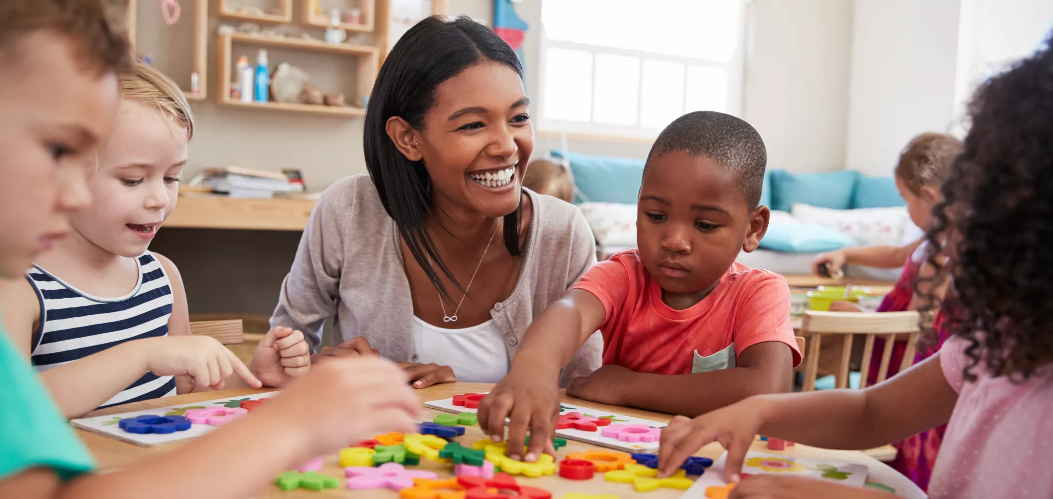 teacher with her preschoolers as they are working on an art activity